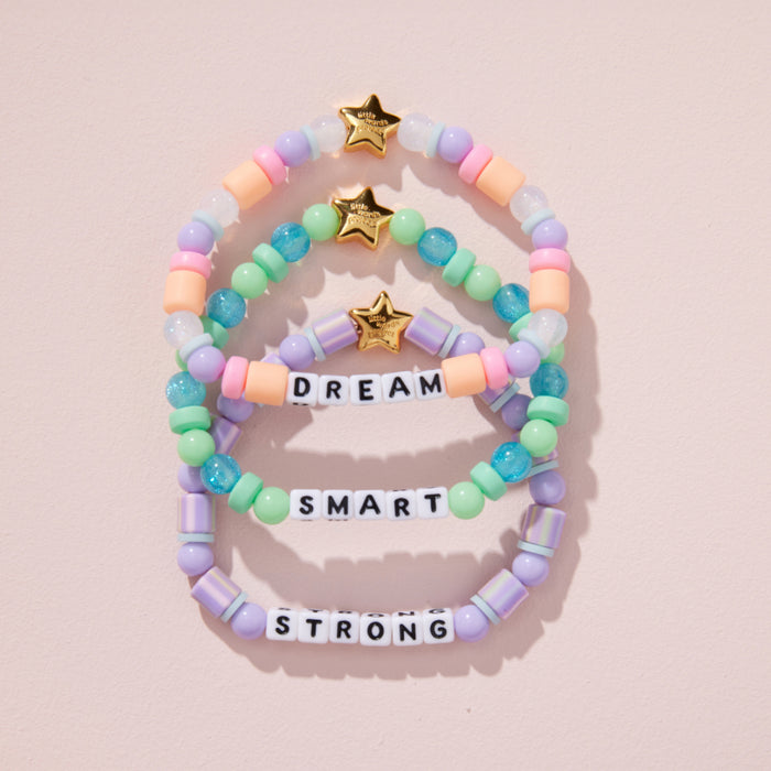 Colorful beaded bracelets with motivational text on a pink background