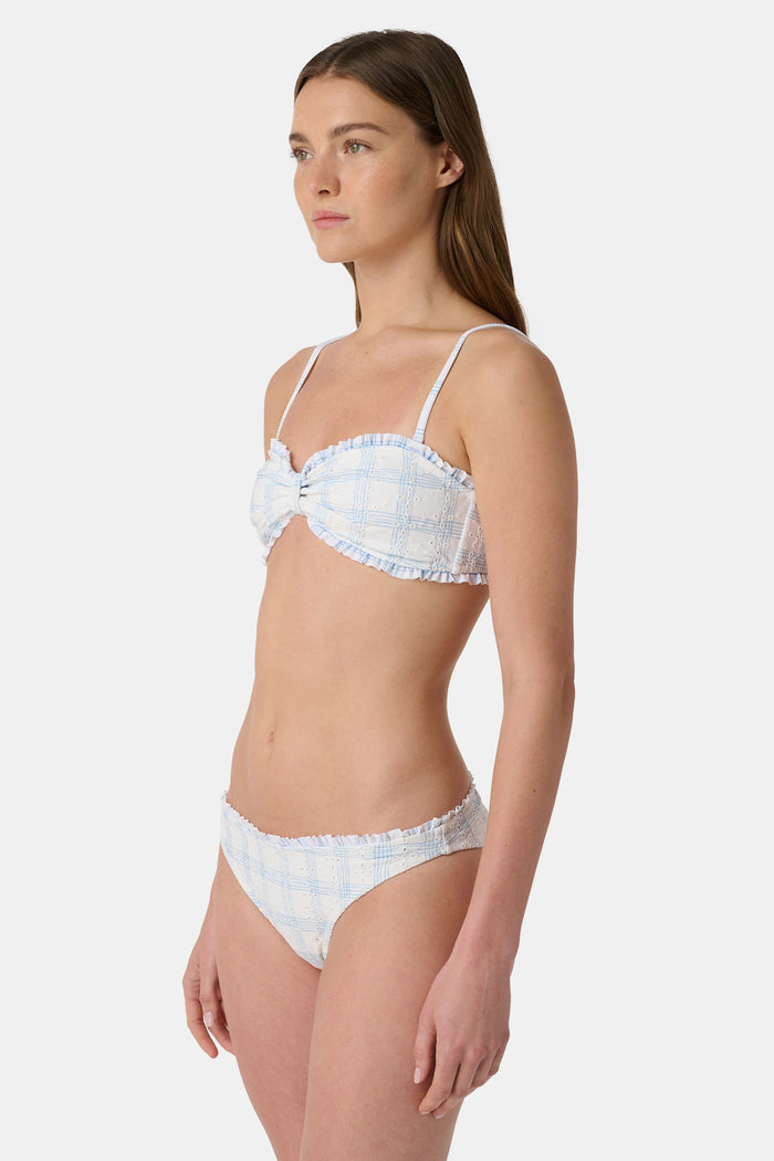 A woman wears the Roller Rabbit Sun Check Eyelet Sydney Bikini Top, featuring ruffle trim and adjustable straps, against a plain light background.