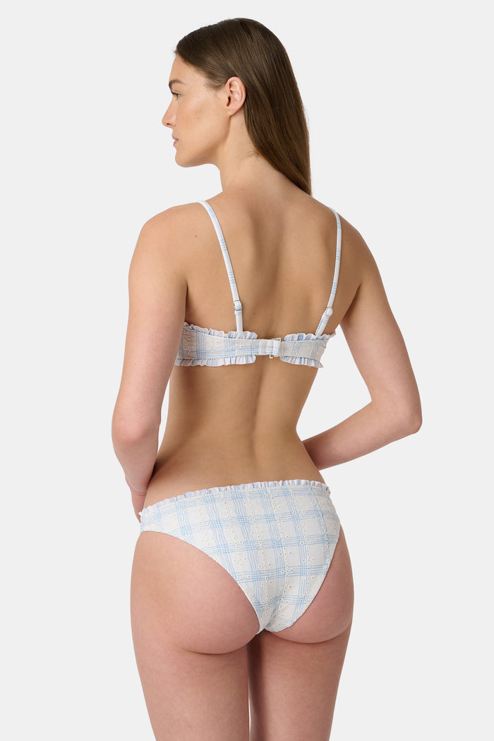 A woman wears the Roller Rabbit Sun Check Eyelet Sydney Bikini Top, featuring ruffle trim and adjustable straps, against a plain light background.