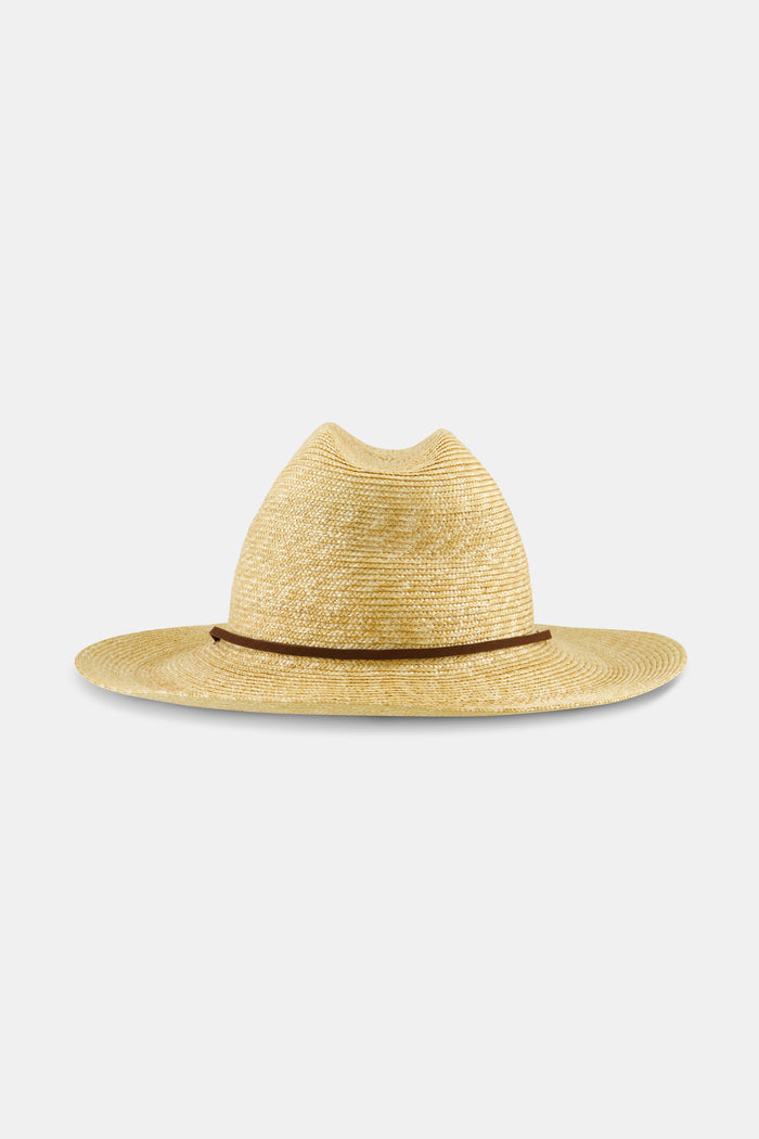 A woman with long brown hair wears the Hat Attack Willow Mini Surfer Hat and a white embroidered button-up shirt, looking down with a gentle expression against a plain background.