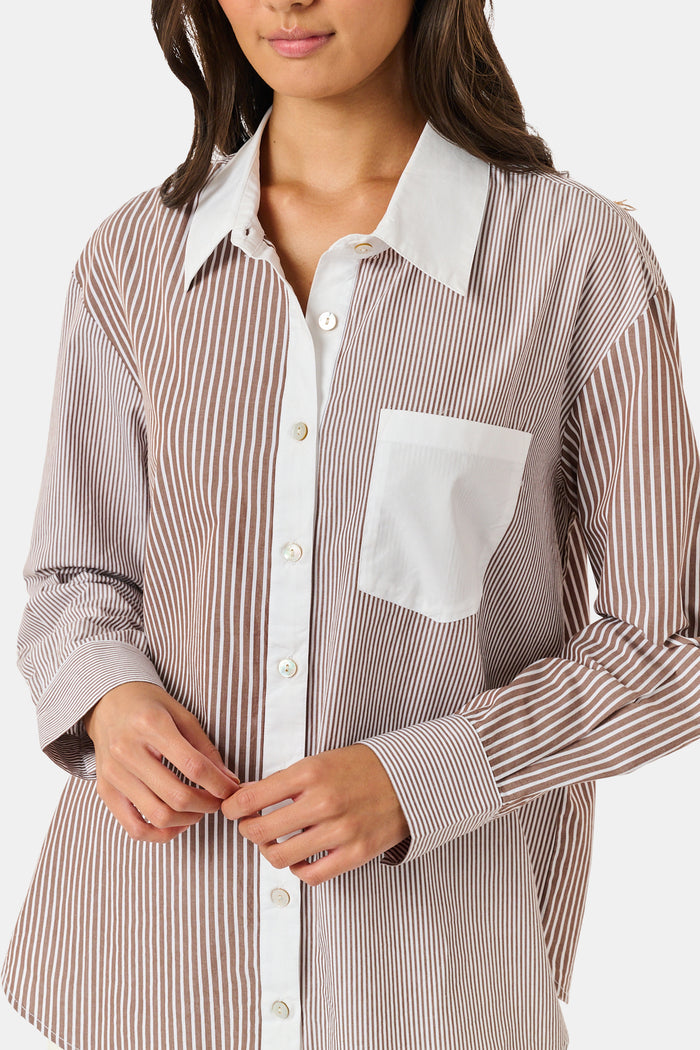 A woman wearing the Roller Rabbit Yarn Dye Stripe Emory Dress—a cotton button-down style with a tie belt and white collar—smiles while looking to the side and pairs the dress with knee-high boots. The background is plain light gray.